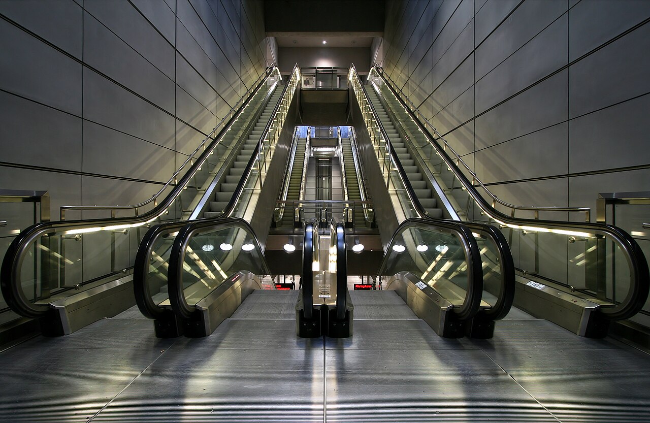 Escalators carrying passengers upward in the Copenhagen Metro.